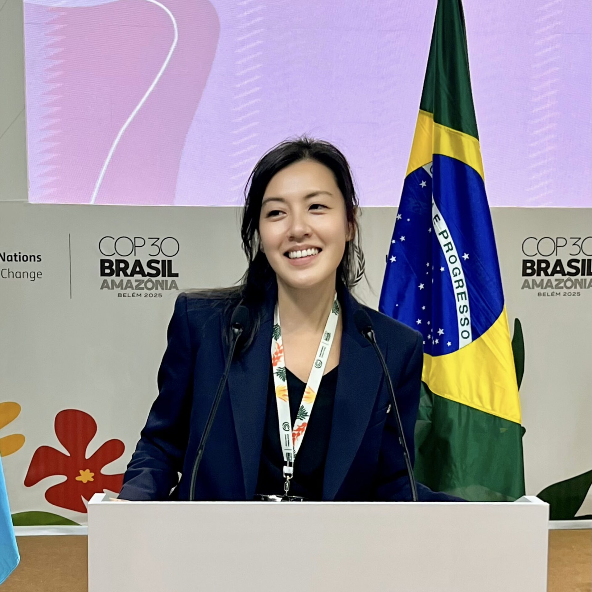 Women with dark hair, smiling at a podium